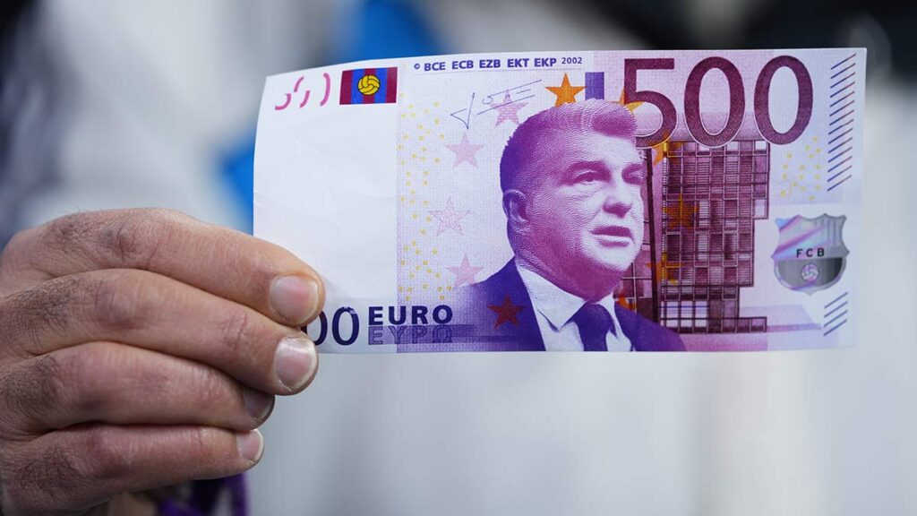 Un aficionado sostiene un billete falso con la imagen de Joan Laporta. AP