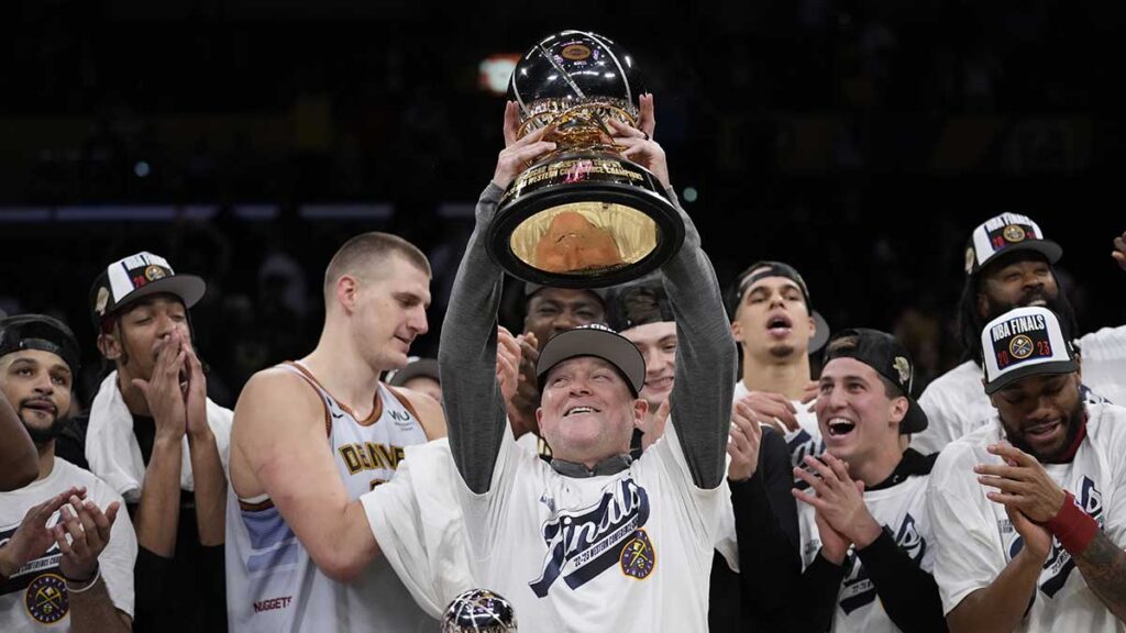 El entrenador de los Nuggets de Denver sostiene el trofeo de campeón de conferencia. AP