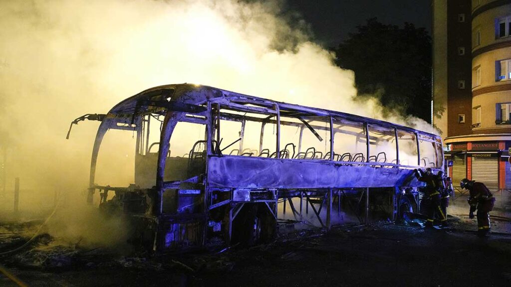 Bomberos arrojan agua a un autobús quemado, el sábado 1. AP