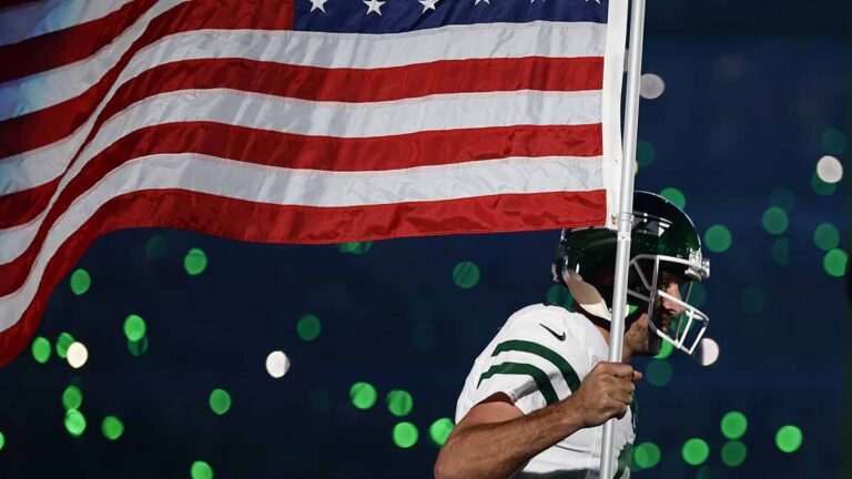 Aaron Rodgers entra con la bandera de Estados Unidos en honor a las víctimas del 9/11 en su primer partido con los Jets