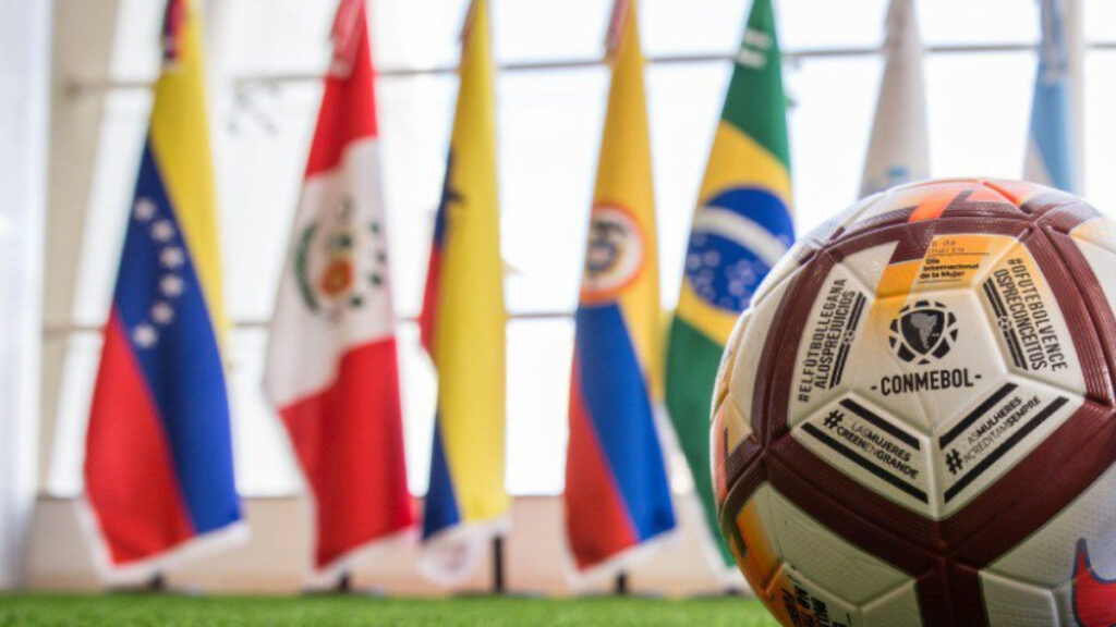 Balón con banderas sudamericanas de fondo. – @CONMEBOL.